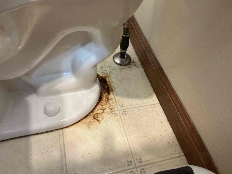 Responded to plumbing lead for potential toilet repair and relocation estimate. Upon arrival, conducted thorough inspection of bathroom facilities and documented existing conditions with photographs. Observed significant rust-colored staining and water damage on vinyl floor tiles surrounding toilet base and water supply line connection point, indicating previous or ongoing leak issues. Examined chrome flexible water supply line with shut-off valve for signs of failure or seepage. Assessed toilet installation, floor condition, and supply line integrity to determine repair requirements. Provided customer with professional assessment of toilet repair needs and prepared estimate for relocating waste tub as requested.