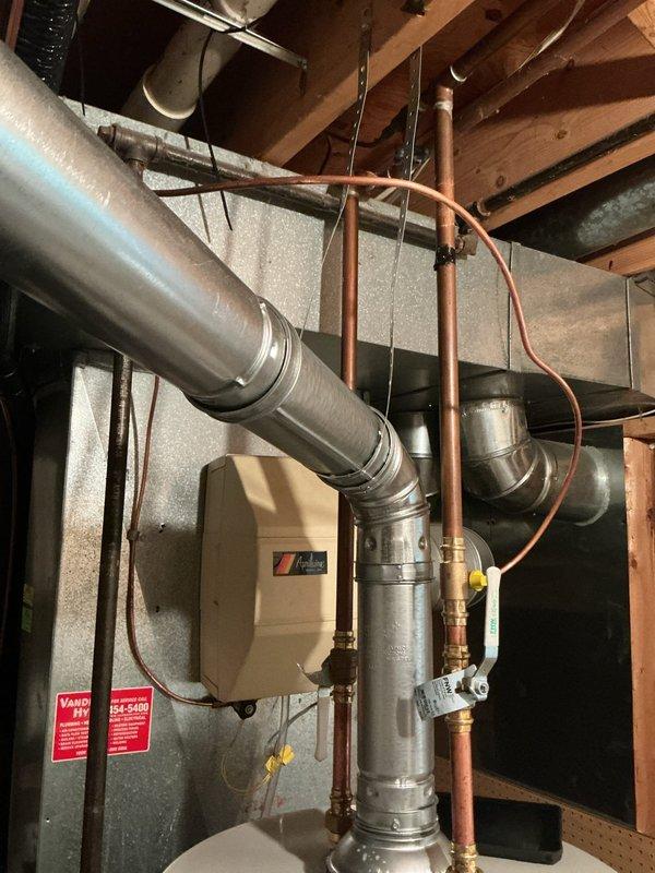 Completed installation of 50-gallon residential water heater with 6-year parts and 1-year labor warranty in basement utility room. Connected copper supply and discharge lines with proper valves and fittings, ensuring all plumbing connections meet code requirements and are properly secured within existing HVAC infrastructure.