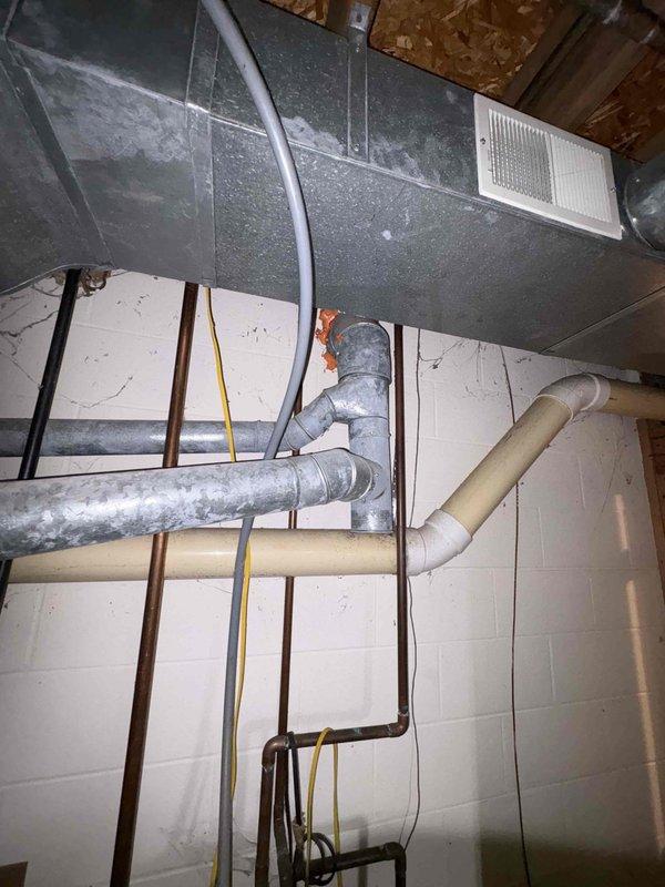 Responded to service call for water heater failure with active leak creating pooling water near unit in 40-year-old residential property. Upon arrival, conducted thorough assessment of standard tank water heater that had ceased heating operations approximately three days prior. Performed visual inspection of unit exterior, internal components, and surrounding plumbing connections to identify source of water leak and heating malfunction. Documented existing conditions through photographic evidence showing basement mechanical room layout, including exposed ductwork, plumbing lines, and utility infrastructure. Evaluated age and condition of water heater tank, checking for corrosion, sediment buildup, and structural integrity of vessel. Assessed all inlet and outlet connections, temperature and pressure relief valve, drain valve, and tank seams for potential leak points. Examined heating elements or burner assembly depending on unit type to determine cause of heating failure. Provided cust