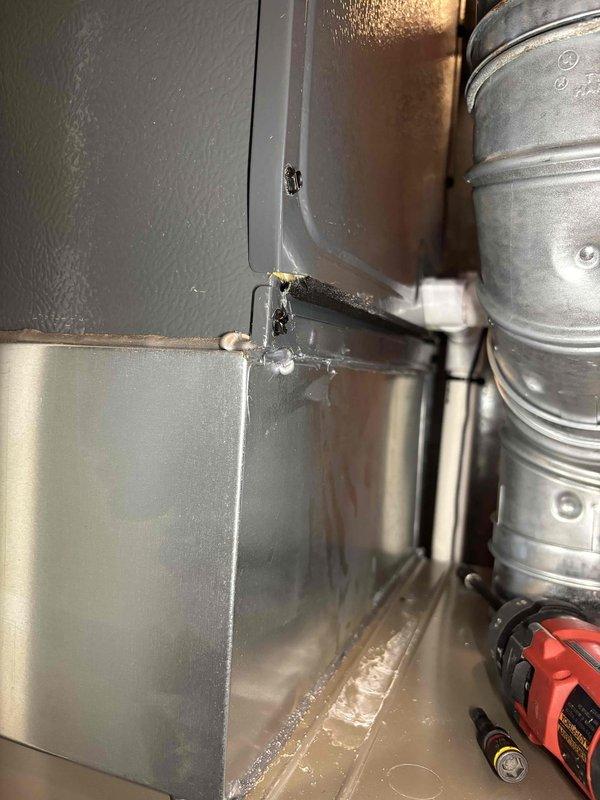 Completed annual cooling maintenance on EnergiAir system. Performed comprehensive inspection of air handler unit, noting degraded gasket material at duct connection point and white residue accumulation in cabinet interior. Inspected blower assembly and condensate drain pan, observing moisture presence and minor staining along seams. Documented equipment condition with photos showing worn foam sealing at ductwork junction and debris collection requiring attention. System operational at time of service.
