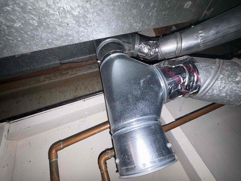 Conducted water heater replacement estimate for existing Lochinvar unit showing signs of age and corrosion, particularly around the top rim and metal components. Documented current installation configuration including copper supply lines, pressure relief valve piping, and surrounding HVAC infrastructure to provide accurate replacement specifications for customer-supplied equipment.