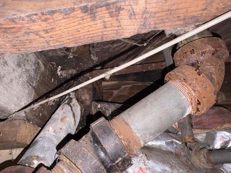 Completed comprehensive plumbing assessment for replacement of deteriorated cast iron piping system and investigation of suspected leak. Inspection revealed severely corroded cast iron pipes in crawl space with extensive rust degradation, pitting, and structural compromise at threaded connections, along with exposed PVC plumbing lines accessed through ceiling opening above stairwell. Documented existing conditions including corroded pipe sections, compromised fittings, and access points required for full system evaluation and provided detailed project estimate for complete pipe replacement.