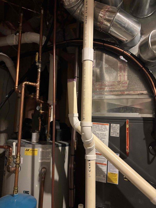 Completed full replacement of two residential air conditioning systems in a same-day installation. Removed existing HVAC equipment and installed new Goodman brand furnace units with integrated cooling systems in basement utility area. 

Installation included complete setup of air handler with proper electrical connections and digital control panel configuration. Ran and secured copper refrigerant lines along wall structures with appropriate insulation and support brackets. Installed blue expansion tank for system pressure regulation. Connected white PVC condensate drainage lines with proper slope and U-trap configuration to ensure efficient moisture removal from the system.

Integrated new equipment with existing ductwork infrastructure, including metallic supply and return ducts. Made all necessary electrical connections to control boards and verified proper voltage and amperage to digital display panels. Ensured all manufacturer warning labels and specification plates remained visibl