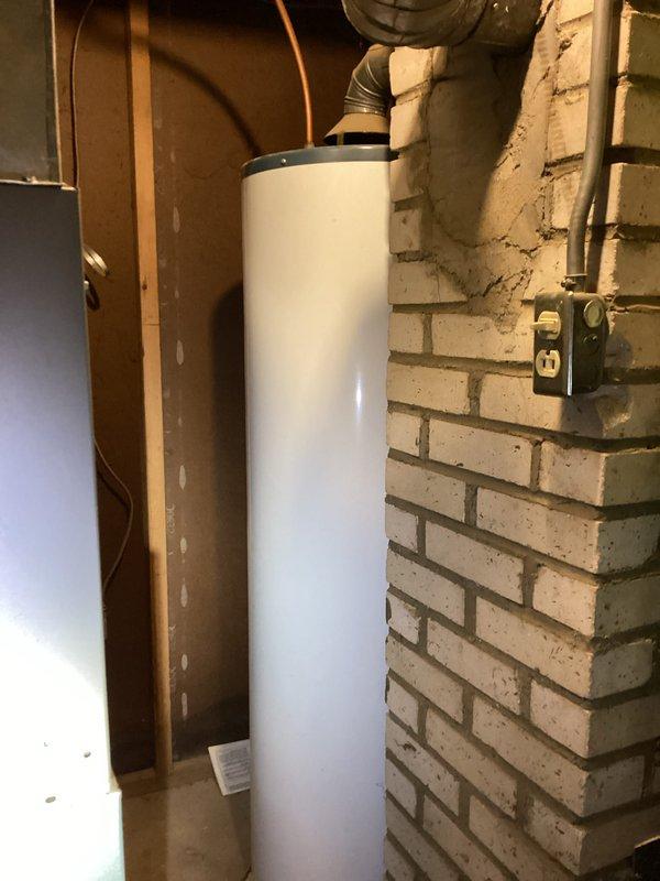Responded to service call for drastically reduced water pressure at property with 25-year-old Rheem water heater. Performed diagnostic inspection of water heater and associated plumbing connections, documenting existing conditions including corroded gas line with visible rust and aging mechanical infrastructure. Identified pressure issue and provided assessment of system components requiring attention.