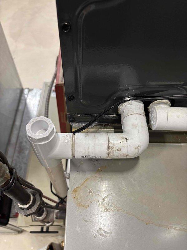 Responded to water leak associated with HVAC system. Upon inspection, identified moisture issues related to condensate drainage system on operational 9-year-old Carrier furnace. Examined PVC condensate drain lines showing age-related discoloration and staining. Inspected drain pan, piping connections, and electrical components for proper function. Documented existing conditions with photographs showing condensate line configuration and system components. System remains operational with both heating and cooling functions intact.
