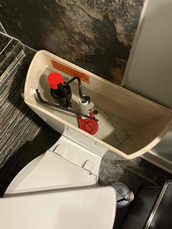 Responded to basement toilet running continuously. Removed tank lid and inspected internal flush mechanism components. Found faulty fill valve causing constant water flow into tank. Replaced defective fill valve assembly with new unit, adjusted float ball height to proper water level, and tested flush cycle for proper operation. Verified toilet now fills correctly and shuts off completely without continuous running. Also noted severe mold and water damage present on ceiling and wall surfaces surrounding toilet, indicating significant moisture intrusion issues requiring separate remediation attention.