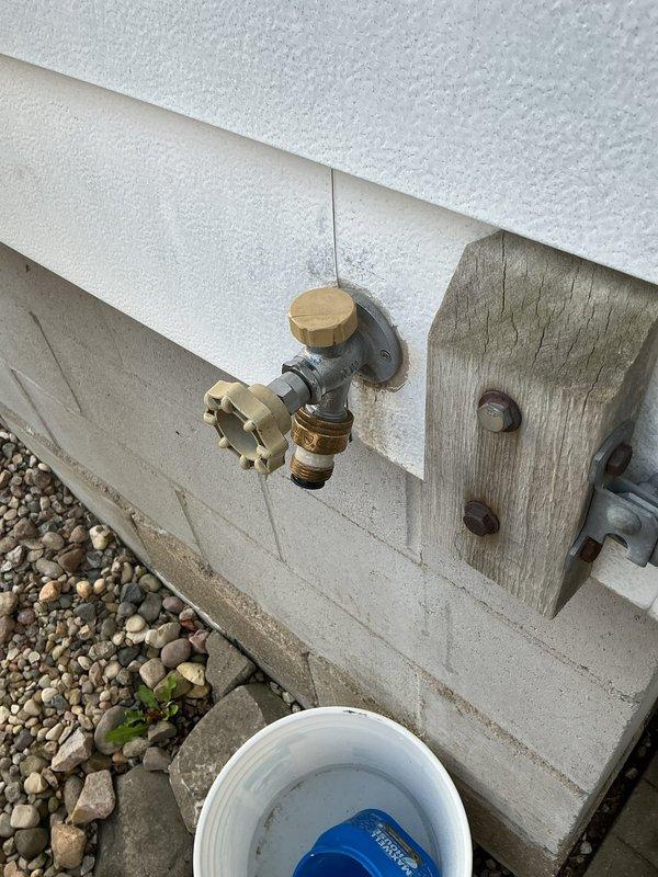 Replaced malfunctioning outdoor garden faucet on 50-60 year old home. Removed old hose bib mounted on exterior wall above concrete foundation and installed new brass frost-free sillcock with proper mounting hardware. Accessed interior ceiling space to verify supply line connection and ensure proper installation of new fixture without leaks.