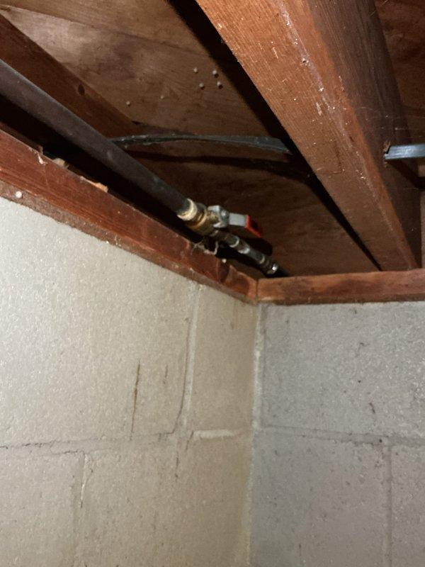 Replaced malfunctioning outdoor garden faucet on 50-60 year old home. Removed old hose bib mounted on exterior wall above concrete foundation and installed new brass frost-free sillcock with proper mounting hardware. Accessed interior ceiling space to verify supply line connection and ensure proper installation of new fixture without leaks.