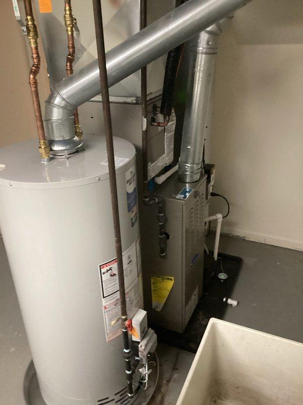 Completed installation of 40-gallon natural gas water heater with 6-year tank and 6-year parts warranty in residential utility room. Unit was installed in short configuration with proper venting through existing exhaust system, copper supply line connections, and gas line hookup with shutoff valve. All plumbing connections were secured with appropriate fittings, system was tested for proper operation and safety compliance, and installation met manufacturer specifications and local code requirements.