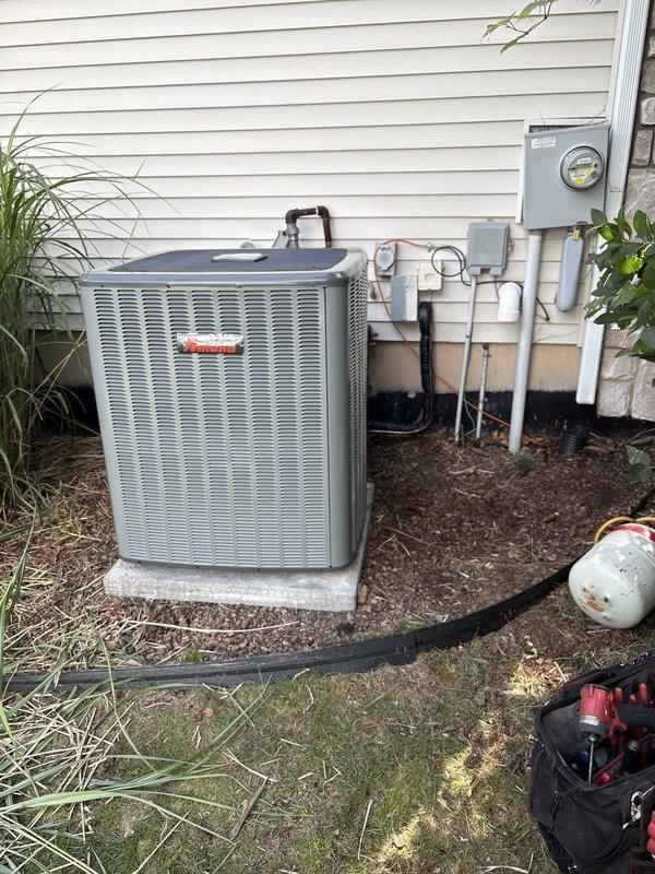 Completed full residential air conditioning system replacement including outdoor Amana condenser unit and indoor air handler. Installed new condenser on existing concrete pad with proper refrigerant line connections, electrical disconnect, and condensate drainage. Mounted indoor air handler in basement mechanical room with new ductwork integration. System commissioned, tested for proper operation, and verified all electrical connections meet code requirements.