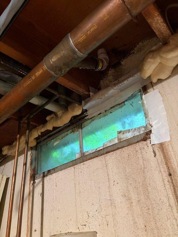 Responded to basement plumbing leak reported by customer with accompanying photos. Upon arrival, located leak source at copper pipe joint near ceiling joists in utility area adjacent to washing machine. Inspected exposed copper piping system showing signs of age and oxidation, identified failed solder joint as primary leak point. Shut off water supply, drained affected line, and performed professional repair using torch soldering technique to reseal compromised joint. Verified all pipe connections and mounting brackets for stability. Tested system under full pressure to confirm leak elimination with no additional drips or moisture detected. Advised customer to monitor area for next 24-48 hours and provided recommendations for future preventive maintenance on aging copper plumbing system.