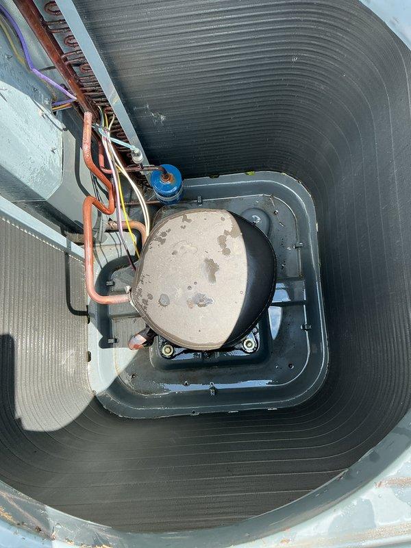 Completed annual cooling maintenance on 2016 EnergiAir system. Performed comprehensive inspection of condensing unit located in protective metal enclosure. Removed accumulated debris, leaves, and organic matter from drain pan and unit base. Inspected refrigerant lines, electrical connections, and control wiring—all found secure and operational. Verified proper drainage and cleared blockages from condensate system. Documented equipment condition with photos showing copper refrigerant lines, service ports, and overall unit status before and after cleaning. System tested and operating within normal parameters.