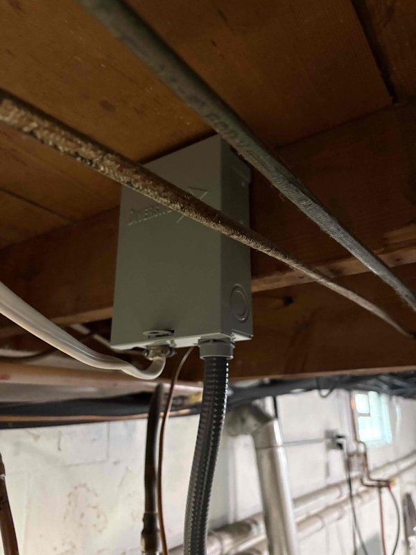 Completed installation of a 50-gallon short electric water heater in basement utility area. Removed existing unit and installed new water heater with proper electrical connections via junction box and flexible conduit, connected copper supply and discharge lines with brass fittings and valves, and ensured unit was level and properly positioned on concrete floor against foundation wall. All plumbing connections were secured and tested for leaks, electrical wiring was verified for safe operation, and installation meets code requirements for residential electric water heater systems.