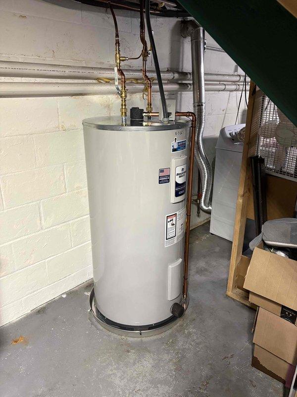 Completed installation of a 50-gallon short electric water heater in basement utility area. Removed existing unit and installed new water heater with proper electrical connections via junction box and flexible conduit, connected copper supply and discharge lines with brass fittings and valves, and ensured unit was level and properly positioned on concrete floor against foundation wall. All plumbing connections were secured and tested for leaks, electrical wiring was verified for safe operation, and installation meets code requirements for residential electric water heater systems.