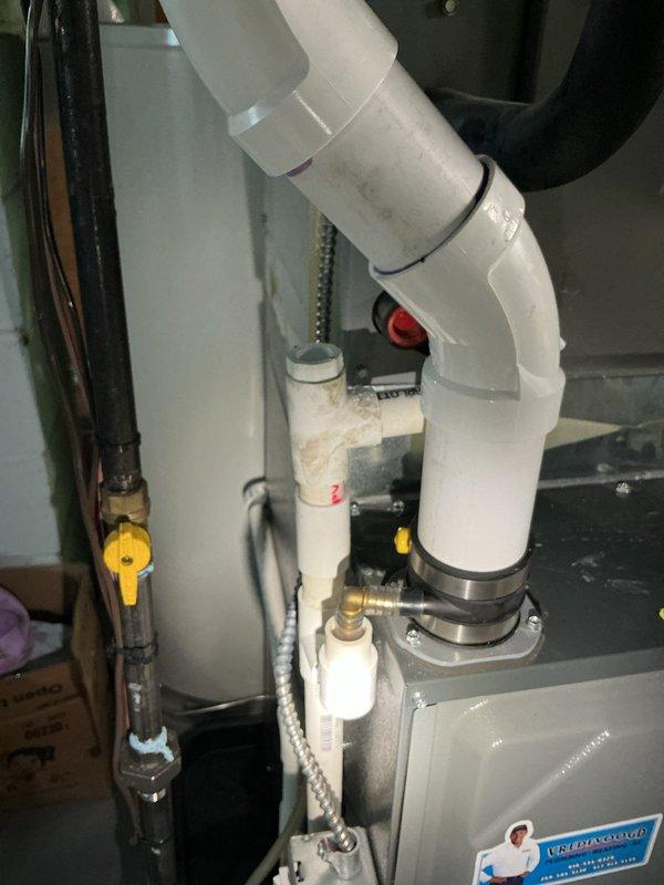 Responded to service call regarding cleanup required after previous appointment. Upon arrival, inspected HVAC system including Energi Elite Series furnace unit and associated condensate drain system with white PVC piping configuration. Documented current condition of mechanical room and equipment through photographic documentation. Cleaned utility area surrounding furnace and water heater installations, removing debris and organizing workspace. Verified all PVC condensate drain connections, coupling bands, and piping routes were properly secured. Inspected braided flex lines, yellow valve components, and vertical black piping runs for proper installation. Ensured all equipment labels and safety warnings remained visible and intact on furnace unit. Left mechanical room in clean, organized condition with all components properly positioned and accessible for future service needs.
