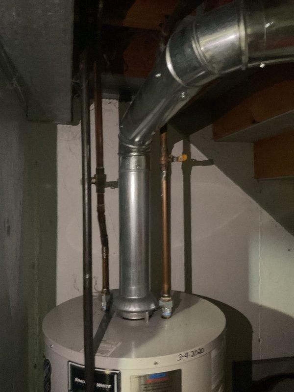 Responded to a water heater leak on a 6-year-old unit. Upon inspection, discovered significant rust and corrosion on the cold water inlet connection, including the dielectric union and threaded fittings. Documented the corroded components with photos showing deterioration around the pipe connections at the top of the tank, which was the source of the leak.
