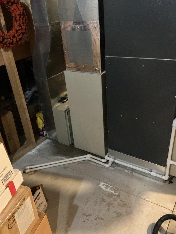 # Water Leak Service Call

Responded to water leak in basement utility area. Upon arrival, found active water intrusion affecting concrete floor with visible moisture and standing water in corner near HVAC equipment. Identified source of leak originating from plumbing system along wall where multiple PVC pipes converge. 

Deployed absorbent materials to contain spreading water and protect nearby stored items and cardboard boxes. Assessed extent of water damage to unfinished basement space, noting moisture penetration on concrete floor and potential impact to wall materials in various stages of construction. Inspected white window air conditioning unit positioned in affected area to ensure no water damage to electrical components.

Evaluated plumbing configuration and pipe connections at corner junction where leak was most prominent. Documented conditions of surrounding construction materials including exposed framing, drywall panels, and wall openings. Provided recommendations for wate