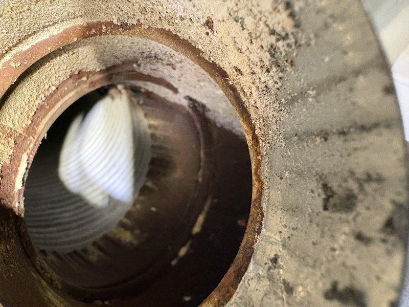 Responded to water heater leak complaint on unit over 10 years old. Upon inspection, identified severe corrosion on drain valve and temperature/pressure relief valve discharge piping connections. Extensive rust accumulation observed at pipe fittings and joints, indicating prolonged moisture exposure and deterioration of metal components. Documented conditions with photos showing corroded pipe fittings at concrete floor penetration and heavy oxidation at connection points. Advised customer of findings and discussed replacement options given age of unit and extent of corrosion damage.