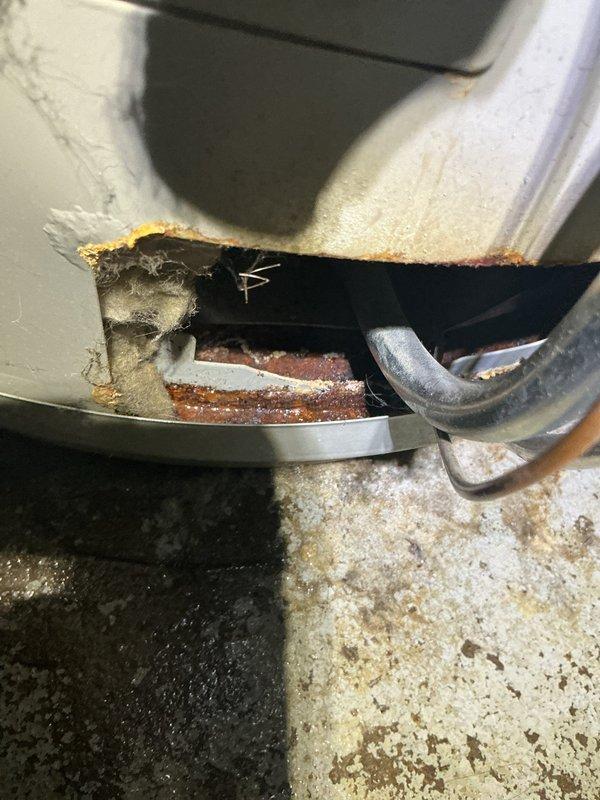 Responded to water heater leak complaint on unit over 10 years old. Upon inspection, identified severe corrosion on drain valve and temperature/pressure relief valve discharge piping connections. Extensive rust accumulation observed at pipe fittings and joints, indicating prolonged moisture exposure and deterioration of metal components. Documented conditions with photos showing corroded pipe fittings at concrete floor penetration and heavy oxidation at connection points. Advised customer of findings and discussed replacement options given age of unit and extent of corrosion damage.