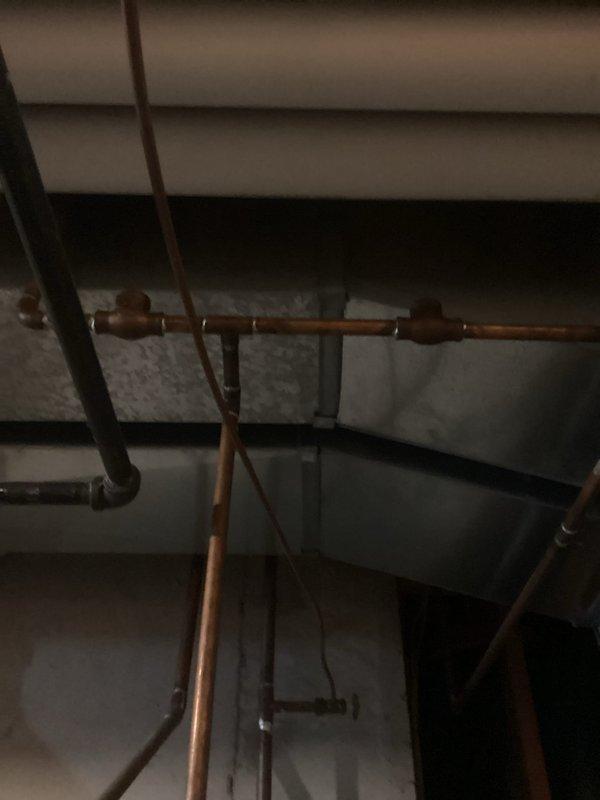 Responded to service call addressing multiple plumbing concerns throughout the residence. Inspected and documented main water supply lines and shutoff valve system in basement mechanical space, photographing copper supply lines, PVC drainage systems, and existing shutoff configuration for whole-home water control estimate. Evaluated hot water heater for inconsistent heating performance and documented unit specifications including age and manufacturer information. Replaced washing machine supply hoses with new reinforced stainless steel braided hoses to prevent potential failure. Diagnosed and repaired leaking kitchen faucet by replacing worn cartridge and O-rings. Adjusted toilet flush mechanism and replaced flapper valve to restore consistent full-flush operation.