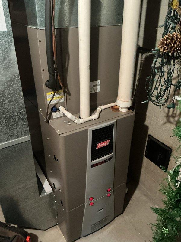 Completed annual cooling maintenance on a 20-year-old Coleman HVAC system. Performed comprehensive inspection of furnace unit, condensate drain lines, electrical connections, and ductwork in basement installation. All components operating within normal parameters at time of service, with PVC drainage system and venting properly configured. Documented equipment condition with photos showing water heater and HVAC installation layout for service records.