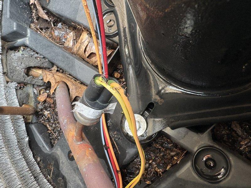 Responded to no-cooling complaint on 6-year-old American Standard air conditioning system. Upon inspection, found outdoor unit heavily contaminated with organic debris including leaves, dirt, and decomposed matter accumulated throughout interior components. Extensive corrosion observed on copper refrigerant lines, metal brackets, and structural supports indicating prolonged moisture exposure. Condenser coil fins showed dirt accumulation affecting heat transfer efficiency. Electrical connections and capacitor inspected amid debris buildup. Cleaned debris from unit interior, removed organic matter from around compressor and electrical components. Assessed system for additional damage from environmental exposure and verified proper airflow restoration through condenser coil after cleaning.