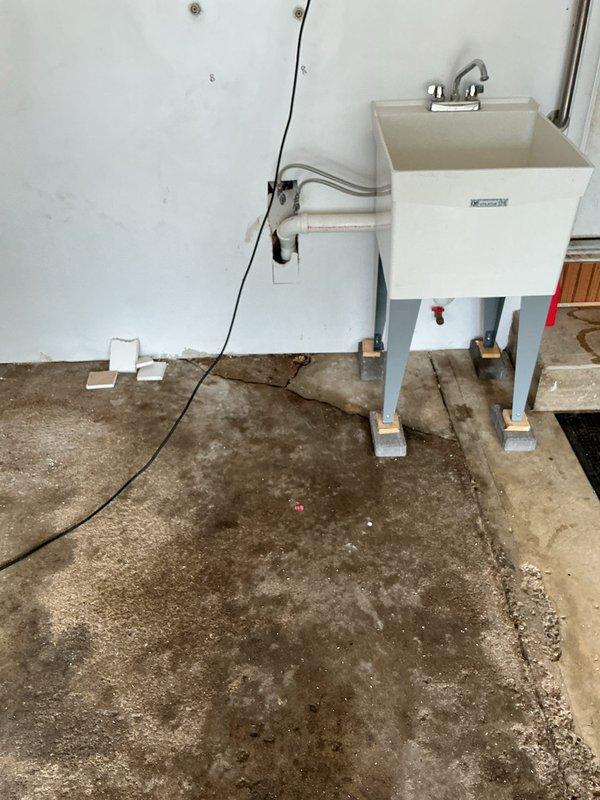 Returned to complete previously quoted plumbing repair on utility sink drainage system. Elevated laundry tub basin using brick supports under metal leg footings to achieve proper trap height and eliminate standing water issues. Installed coupling to complete drain connection at corrected elevation, ensuring proper drainage flow and code-compliant trap configuration.