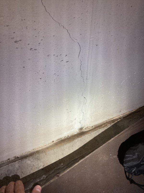Responded to water leak investigation in basement. Upon arrival, inspected affected area and documented extensive moisture damage along interior corner walls with significant vertical cracking at wall seam and water staining near floor level. Photographed damaged areas showing deteriorated wall surfaces with discoloration and evidence of ongoing moisture intrusion at foundation level. Recommended follow-up assessment to determine source of water penetration and develop comprehensive repair plan for structural crack sealing and moisture remediation.