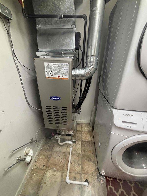 Completed full HVAC system installation including new Carrier furnace and air conditioning unit in residential utility space. Installed air handler with filter box assembly, connected rigid and flexible ductwork, and ran PVC condensate drain lines throughout mechanical room. Mounted electrical controls and verified all connections for proper system operation.