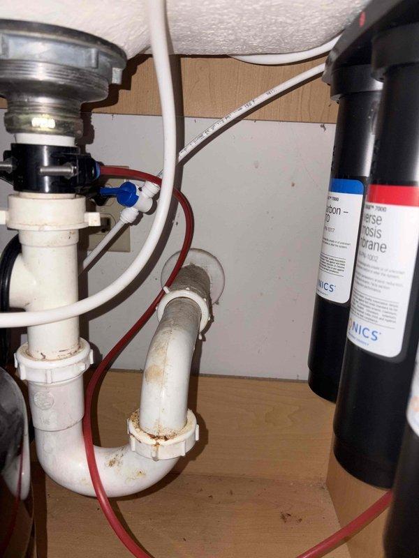 Performed water heater tune-up and comprehensive inspection of water softener system and under-sink plumbing components. Verified proper operation of garbage disposal, P-trap drainage assembly, and water filtration system with all connections secure and functioning correctly. Water supply to softener was restored after confirming system integrity and proper installation of all plumbing components.