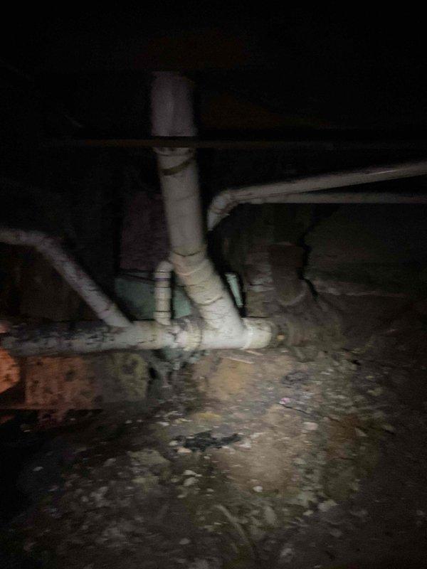 Responded to drain problem and performed inspection of crawl space plumbing system. Documented existing conditions including multiple PVC drain lines, pump assembly with housing, and concrete floor showing moisture staining and deterioration. Determined that hydrojetting service is required to properly address the drainage issue. Photographed crawl space access area showing structural components, HVAC ductwork, and plumbing configuration for follow-up service scheduling.