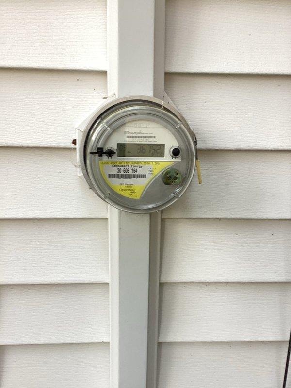 Completed electrical meter upgrade estimate for 66-year-old single-family residential property. Inspected existing digital electric utility meter mounted on exterior wall with white vinyl siding, confirmed meter in good working condition with no visible damage or deterioration. Documented current electrical service configuration and photographed meter installation for estimate preparation.