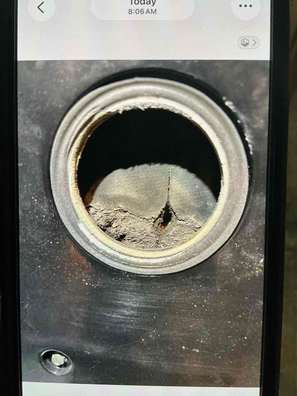 Returned to site to remove and replace hot water heater per previously quoted repair. Upon arrival, inspected tank connections and surrounding area. Documented significant sediment accumulation at base of flue pipe opening and rust staining around combustion chamber access port, indicating advanced age and deterioration of unit. Successfully disconnected water supply lines, gas line, and venting components. Removed failed water heater from premises. Installation area cleaned and prepared for replacement unit. All work completed according to quoted specifications.