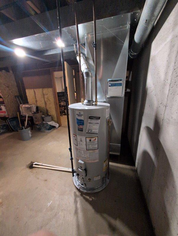 Successfully installed a new residential water heater in the basement utility area. The unit was positioned on the concrete floor with all necessary connections completed, including water supply lines, gas or electrical connections, and proper venting through the flue system. All piping connections were secured and tested for proper operation. The installation was completed in coordination with existing HVAC equipment and mechanical systems in the space, ensuring adequate clearance and access for future maintenance.