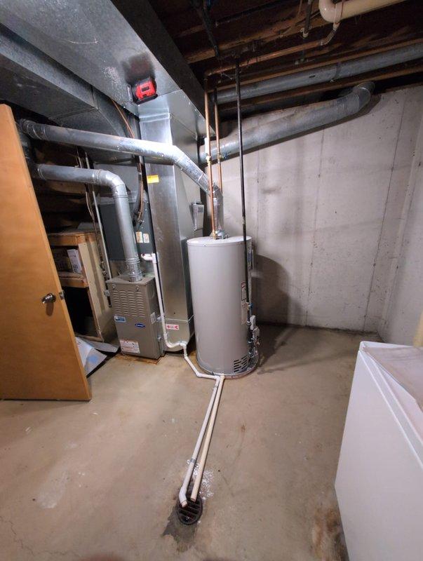 Successfully installed a new residential water heater in the basement utility area. The unit was positioned on the concrete floor with all necessary connections completed, including water supply lines, gas or electrical connections, and proper venting through the flue system. All piping connections were secured and tested for proper operation. The installation was completed in coordination with existing HVAC equipment and mechanical systems in the space, ensuring adequate clearance and access for future maintenance.