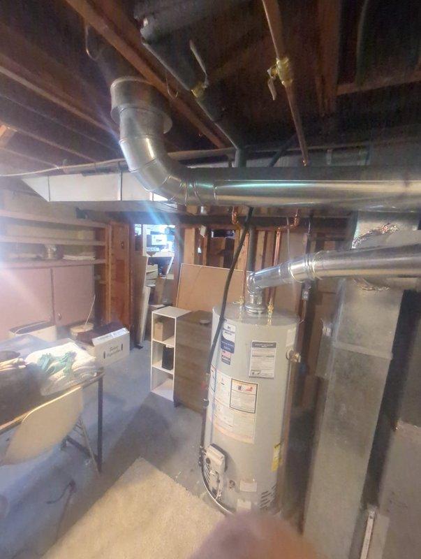 Completed installation of a 40-gallon natural gas water heater in basement utility area. Removed existing unit and installed new tall model with proper venting connections to existing horizontal ductwork system. Connected copper supply lines with brass fittings and shutoff valves, ensuring secure water connections at top of unit. Verified proper draft hood installation and gas line connections for safe operation. Tested all plumbing connections for leaks and confirmed proper water heater functionality upon completion.