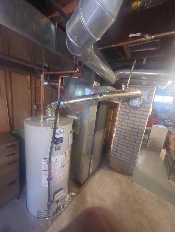 Completed installation of a 40-gallon natural gas water heater in basement utility area. Removed existing unit and installed new tall model with proper venting connections to existing horizontal ductwork system. Connected copper supply lines with brass fittings and shutoff valves, ensuring secure water connections at top of unit. Verified proper draft hood installation and gas line connections for safe operation. Tested all plumbing connections for leaks and confirmed proper water heater functionality upon completion.