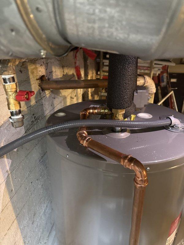 Reworked the pressure relief (PR) tube discharge piping on the water heater installation to improve accessibility for future maintenance and replacement. Reconfigured copper piping and fittings to provide a more serviceable layout while maintaining proper code compliance and safety standards.