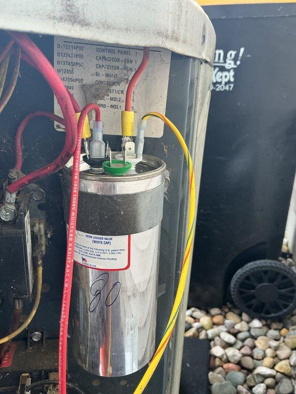 Completed annual cooling maintenance on 13-year-old Trane system. Inspected outdoor condensing unit, photographed and documented capacitor condition showing 80μF dual run capacitor with visible wear and weathering but functioning within specifications. Verified all electrical connections secure with proper wire terminations on capacitor terminals, checked control panel components, and confirmed unit operational status for continued service.