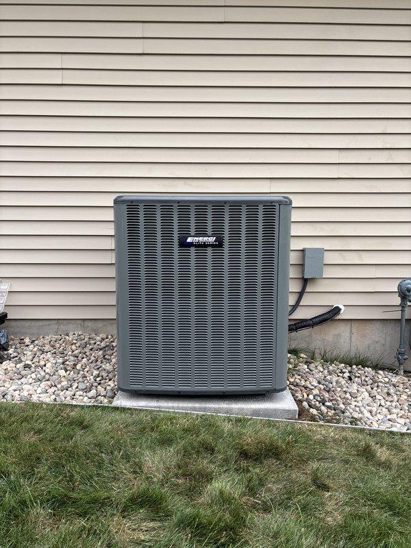 Completed full HVAC system replacement including new air conditioning condensing unit and indoor air handler components. Removed existing equipment and installed new condensing unit on exterior concrete pad with proper clearance and leveling, positioned against house foundation with white rock bed surround. Mounted electrical disconnect box on exterior wall and ran refrigerant lines and electrical conduit from outdoor unit to indoor installation. In basement mechanical room, installed new furnace and air handler assembly between existing support posts with proper clearance specifications. Connected white PVC condensate drainage piping and configured ductwork connections. Verified all electrical connections, tested refrigerant charge levels, and confirmed proper airflow through system. System commissioned and operational upon completion.
