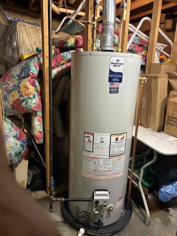 Completed warranty replacement of residential gas water heater with Bradford White RG250T6N model in basement utility area. Removed existing failed unit and installed new 50-gallon atmospheric vent gas water heater. Connected gas supply line, cold water inlet, and hot water outlet piping. Installed proper venting system with metal vent pipe. Verified all connections for leaks, tested gas valve operation, and confirmed proper ignition sequence. Unit operational and heating water as designed upon completion.