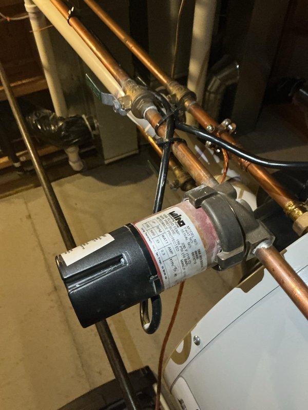 Responded to customer report of rumbling noises from water heater described as sounding like it would explode. Upon inspection, identified sediment buildup in tank causing the rumbling sounds. Inspected hot water circulation pump and associated copper piping system for proper operation and connections. All circulation pump components, fittings, and electrical connections found secure and functioning correctly. Documented system condition with photos showing circulator pump installation and plumbing configuration in mechanical room.