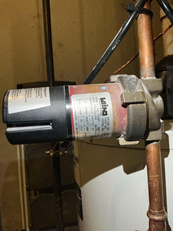 Responded to customer report of rumbling noises from water heater described as sounding like it would explode. Upon inspection, identified sediment buildup in tank causing the rumbling sounds. Inspected hot water circulation pump and associated copper piping system for proper operation and connections. All circulation pump components, fittings, and electrical connections found secure and functioning correctly. Documented system condition with photos showing circulator pump installation and plumbing configuration in mechanical room.
