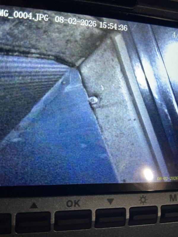 Responded to water leak service call where water was observed in drain pan and unit was not operational. Upon arrival, inspected HVAC system and drainage components. Used inspection camera to examine interior ductwork and metal ventilation components, identifying dust accumulation on surfaces. Evaluated condensate drain line routing, PVC piping connections, and electrical components mounted to equipment cabinet. Inspected drain pan for proper drainage, checked condensate pump operation if applicable, and verified all drain line connections were secure. Examined electrical box connections and wiring integrity. System had been shut down prior to arrival as precautionary measure. Documented conditions with photos of internal ductwork and external equipment configuration including drain lines, electrical components, and associated hardware.