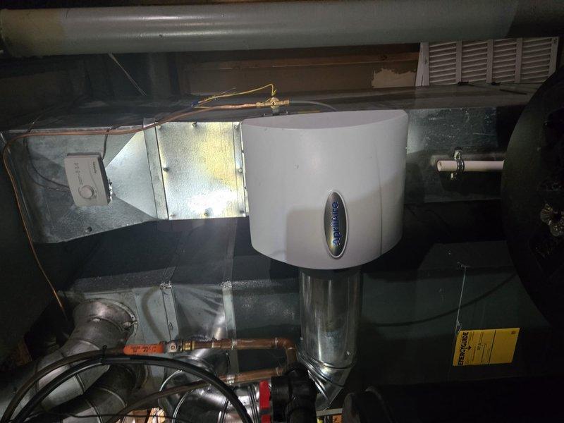 Completed full HVAC system installation including new air handler unit, electrical service panel upgrade, and humidifier integration in residential basement utility area. Coordinated utility company power disconnect and reconnect services to facilitate safe electrical panel replacement. Obtained electrical permit and scheduled inspection with local building authority. Installed vertical air handler with PVC condensate drain lines and armored electrical conduit. Integrated whole-home humidifier unit with copper piping connections to main ductwork system. Completed all electrical connections through new junction box and conduit runs. Verified proper drainage, airflow, and electrical connections throughout system. All work performed to code requirements and passed scheduled electrical inspection.