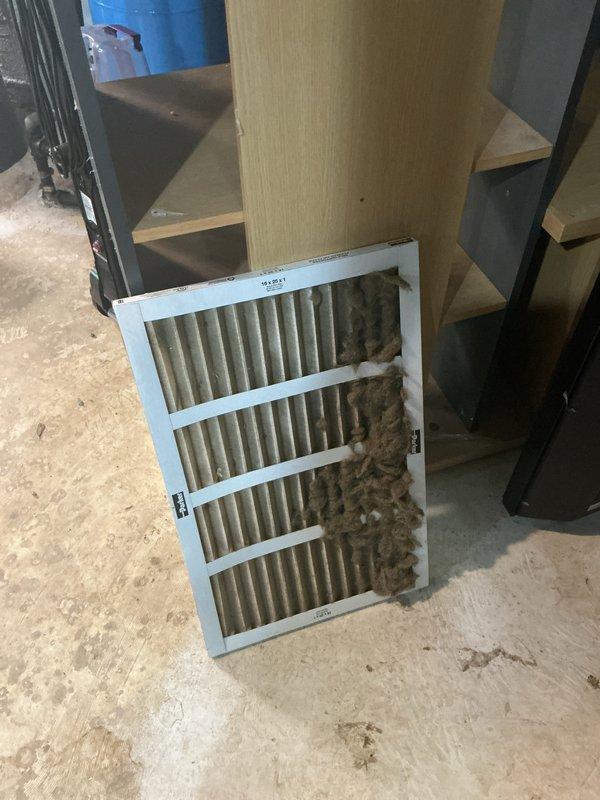 Completed annual cooling maintenance on approximately 5-year-old Lennox system. Replaced heavily soiled air filter that was completely saturated with dust and debris accumulation, significantly restricting airflow. Documented rust-colored staining on ceiling surfaces near utility piping, indicating previous moisture intrusion in area. Performed standard AC tune-up procedures and system operational check. Unit operating properly following filter replacement and maintenance completion.