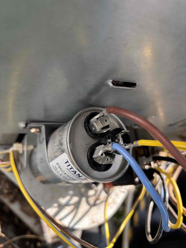 # AC No Cooling - Capacitor Replacement

Responded to service call for air conditioning unit shutting off with buzzing sound and no cold air production. Upon inspection, identified failed TITAN capacitor as root cause of system malfunction. Capacitor showed signs of electrical failure consistent with reported buzzing noise and compressor startup issues. Replaced defective capacitor with new unit matching original specifications. Verified all electrical connections secure and properly terminated. Tested system operation through complete cooling cycle. Unit now running normally with proper compressor startup, no abnormal sounds, and cold air delivery restored. System returned to full operational status.