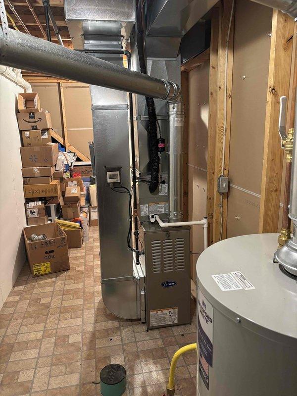 Completed full installation of residential HVAC system including Carrier furnace, air conditioning unit, and water heater in basement mechanical room. All equipment properly positioned, vented, and connected to existing ductwork and plumbing systems. Verified electrical connections, tested system operation with digital multimeter, and confirmed all safety labels and certifications are properly displayed on equipment panels.