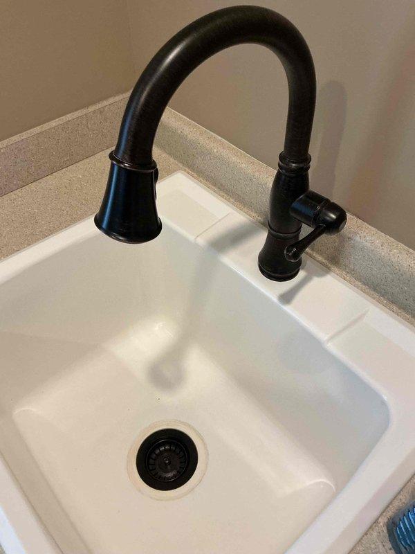 Responded to laundry tub drain stopper issue where the original stopper's finish had worn through and was removed but could not be reinstalled. Sourced and installed a replacement drain stopper assembly compatible with the existing sink configuration. Verified proper operation of the new stopper mechanism and confirmed no leaks present in the drain assembly.