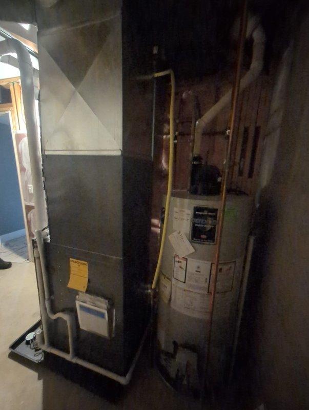 Completed full furnace and air conditioning system installation in basement utility room. Installed new furnace unit on condensate drain pan with proper PVC venting for exhaust and intake, connected copper refrigerant lines to outdoor condenser, and integrated ductwork to existing air distribution system. All equipment mounted securely per manufacturer specifications, system tested and activated successfully.